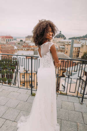 Pretty african bride in vintage lace dress posing for camera on the terrace.の写真素材