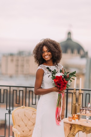 Happy curly black bride on the rooftop smiling. Wedding day.の写真素材
