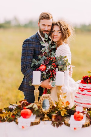 Happy wedding couple smiling at the holiday table. Field background.の写真素材