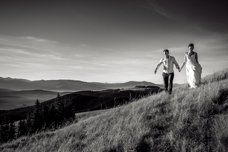 Romantic wedding couple walking in the mountains. Black and white photo.の写真素材