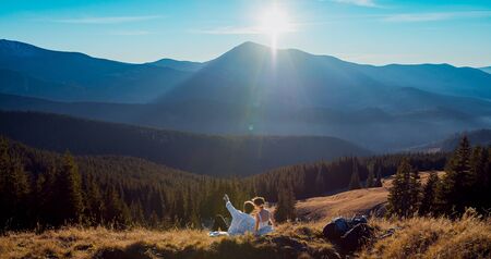 Romantic wedding couple lying on the grass in mountains.の写真素材