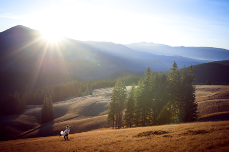 Happy groom holds in hands his beautiful bride. Wonderful mountains landscape.の写真素材