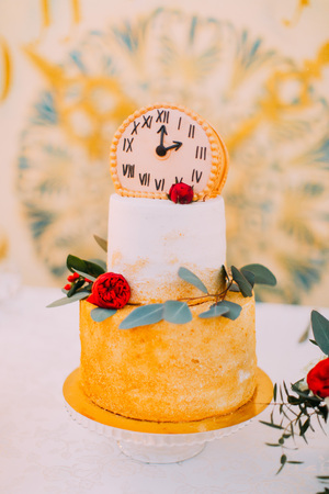 Wedding cake decorated with clocks and flowers close up.の写真素材