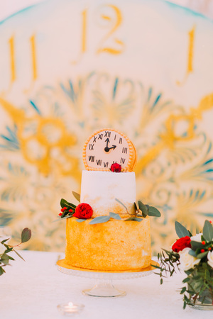Wedding cake decorated with clocks and flowers close up.の写真素材