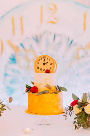 Wedding cake decorated with clocks and flowers close up.の写真素材