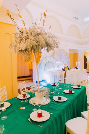 Wedding table with green tablecloth. Wedding celebration in luxurious restaurantの写真素材