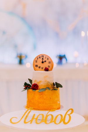 Wedding cake decorated with clocks and flowers close up.の写真素材