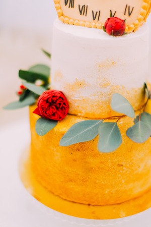 Wedding cake decorated with clocks and flowers close up.の写真素材