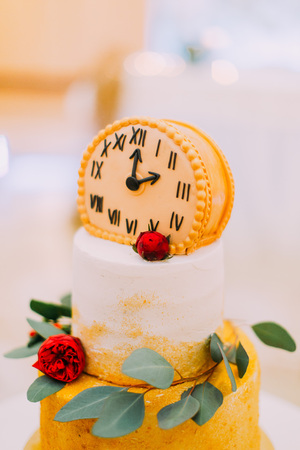 Wedding cake decorated with clocks and flowers close up.の写真素材