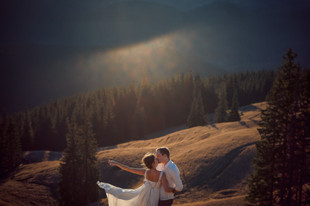 wedding couple kissing. Beautiful mountain landscape on backgroundの写真素材