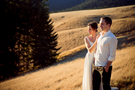 Happy young wedding couple enjoys the mountain landscape.の写真素材