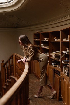 Beautiful young stylish lady on balcony in the vintage library.の写真素材