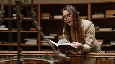 Young beautiful girl reading a book in the vintage library.の写真素材