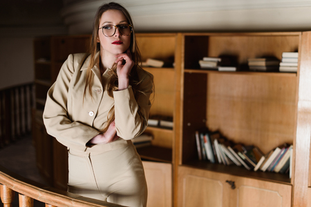 Stylish young lady in glasses posing at the library.の写真素材