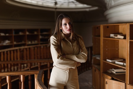 Beautiful young stylish lady posing in the vintage library.の写真素材