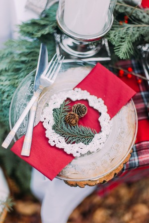 Beautiful decorated christmas table with candles and pines close up.の写真素材