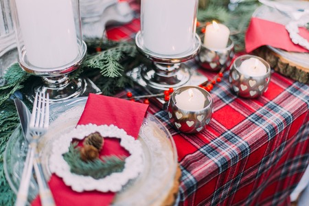 Beautiful decorated christmas table with candles and pines close up.の写真素材