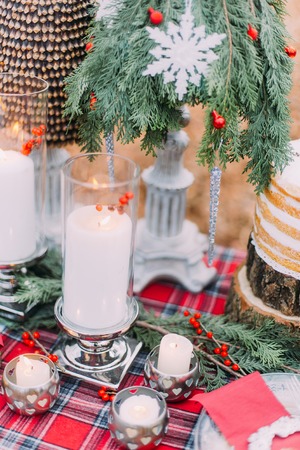 Decorated with candles, branches and berries christmas table close up.の写真素材