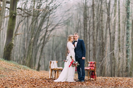 Beautiful wedding couple posing near the decorated for Christmas holidays  table in autumn forestの写真素材