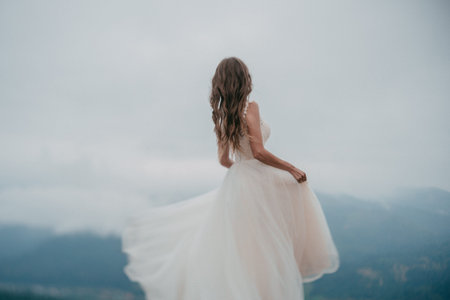 Beautiful bride in white dress posing on the mountain.の写真素材
