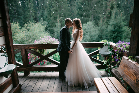 Young married couple standing face-to-face at the balcony and holding hands.の写真素材