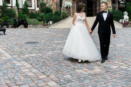 Beautiful young married couple walking and holding hands.の写真素材