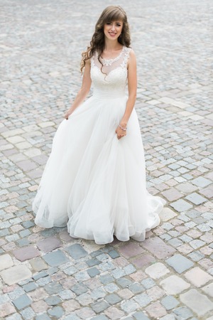 Close up of dreamy beautiful brunet bride walking alone in the park enjoying wind wave and dance.の写真素材