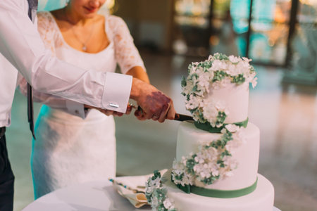 Happy bride and a groom cutting their wedding cakeの写真素材