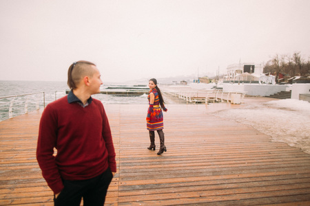 Girl with a guy walking on the dock. Rainy autumn day.の写真素材