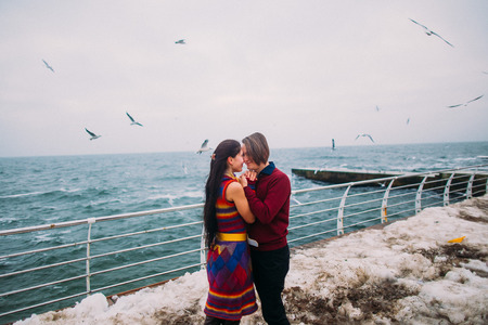 Lovers on the pier and seagulls at background. Romantic honeymoon.の写真素材