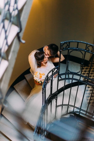 Newly young married couple embracing standing at the stairs.の写真素材