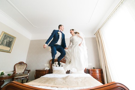 Happy bride jumping on the bed in the rich interiorの写真素材