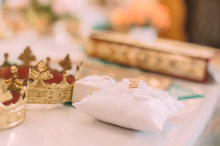 Wedding golden rings on a pillow in the old church.の写真素材
