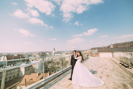 Beautiful groom and bride on roof top building with city backgroundの写真素材