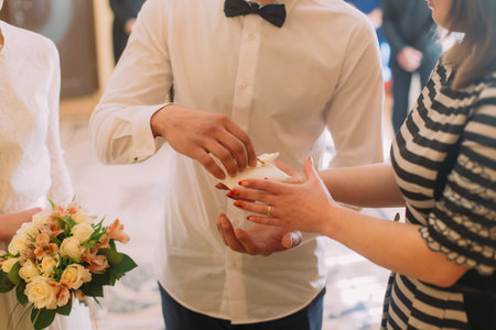 Happy groom taking white pillow witn rings during wedding registration.