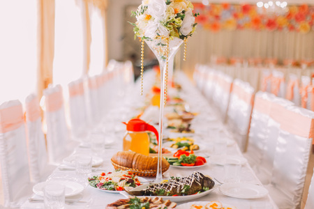 Image of tables setting  in orange colour at a luxury wedding hall, close-up.の写真素材