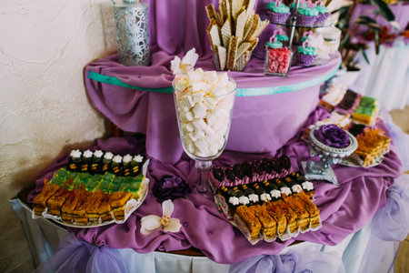 Sweet dessert table or candy bar. Wedding party. Natural light. Macaron and meringue pyramid, cakes and marshmallow.の写真素材