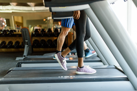 Close-upClose-up of woman's and man's fit legs running on the treadmill of woman's and man's fit legs running on the treadmill.の写真素材
