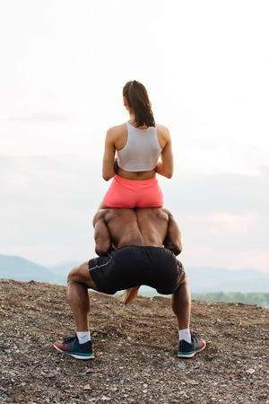 Portrait of a handsome young black african american man giving a piggyback ride to his sexy girlfriend.の写真素材
