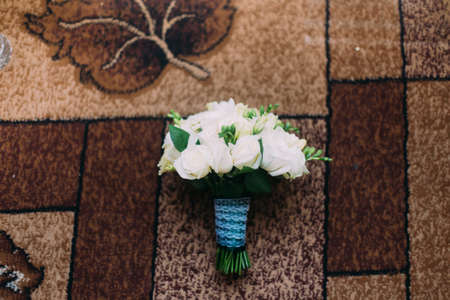 Cute decorative floral bouquet of beautiful flowers on floor carpet with geometric brown pattern.の写真素材
