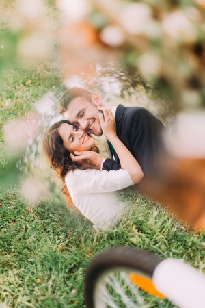 Happy young newlyweds in park. Cheerful couple reflected in bicycle mirror.の写真素材