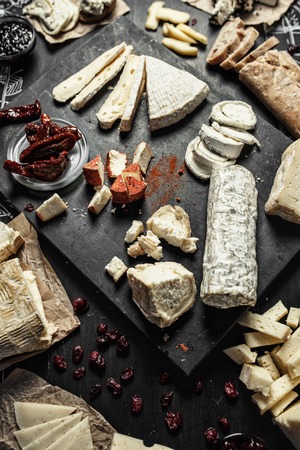 Wine appetizers set on the top view: cheese selection, bread sticks and prunes on the wood serving board backgroundの写真素材