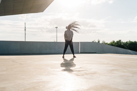 Young african american teenage girl playing with her long dark hair isolated dancing outside.の写真素材