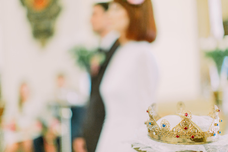 Close-up of crown for Wedding in Orthodox church, blurred married couple on background.の写真素材