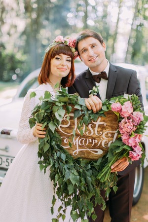 Bride and groom holding Just married sign. Wedding day.の写真素材