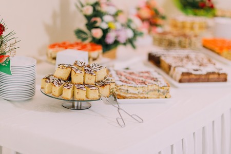 Party hall interior. Assortment of fresh sweet pastry on table in catering buffet.の写真素材