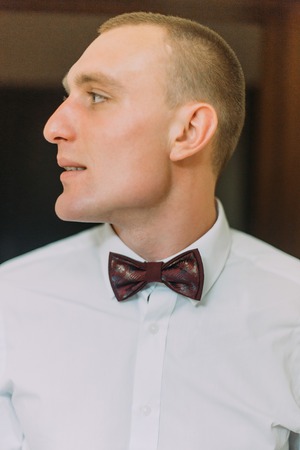 Close-up portrait of handsome young man in bow-tie looking aside.の写真素材