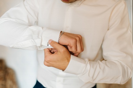 Man in white shirt adjusts his sleevesの写真素材