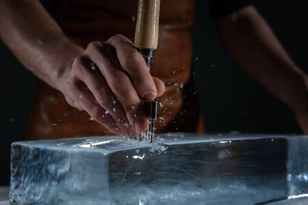 Bartender chopping ice using a special knifeの写真素材