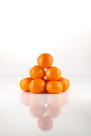 Tangerine oranges pyramid isolated on white background.の写真素材